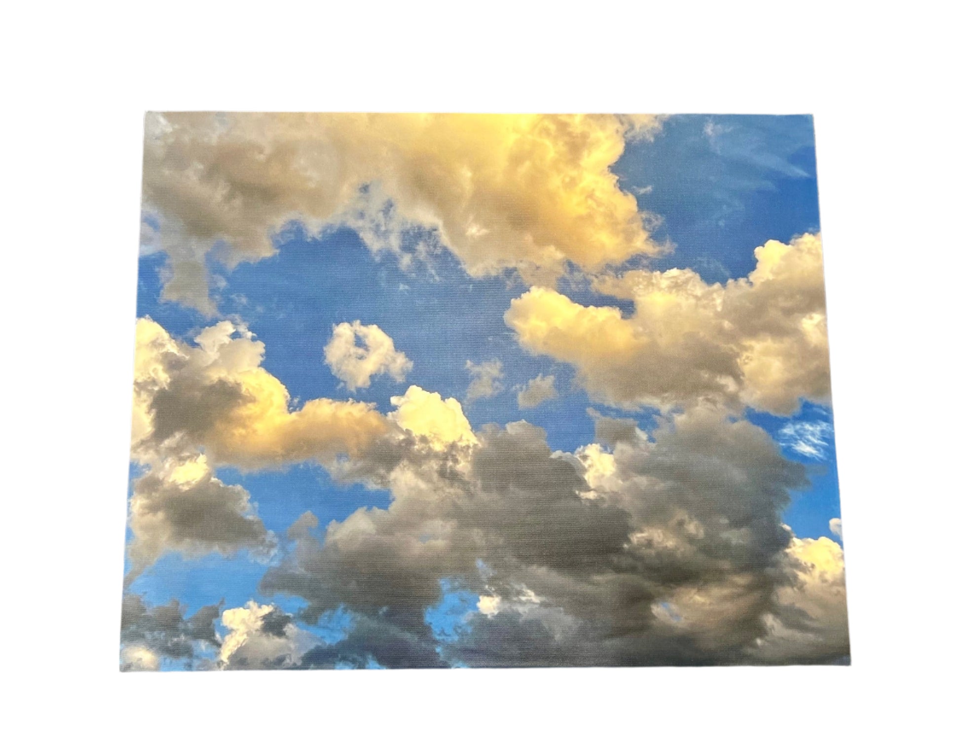Poster of a blue sky with white and yellow clouds on a textured surface.